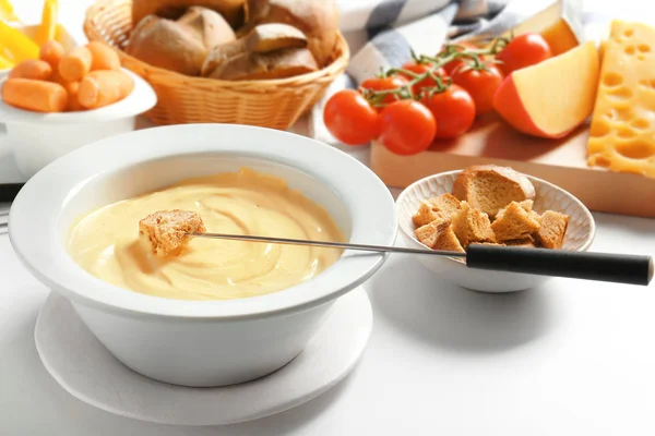 Fondue de queijo na placa e produtos diferentes na tabela branca — Fotografia de Stock