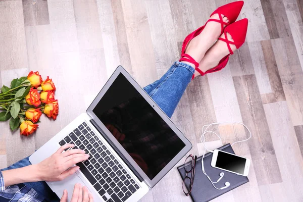 Jovem mulher em sapatos planos elegantes com laptop sentado no chão — Fotografia de Stock