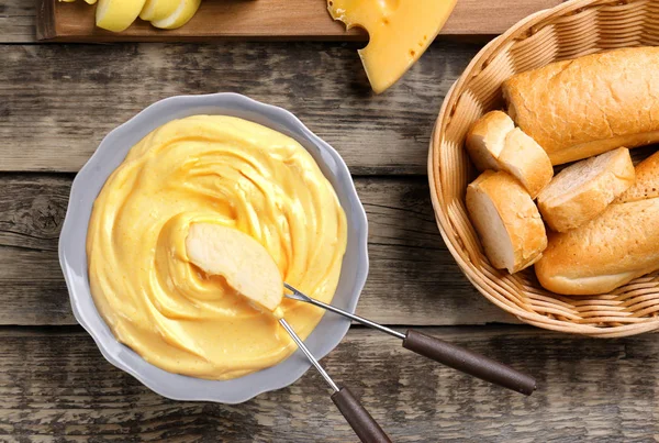 Plasterek Jabłko i ser fondue w plate na drewnianym stole — Zdjęcie stockowe