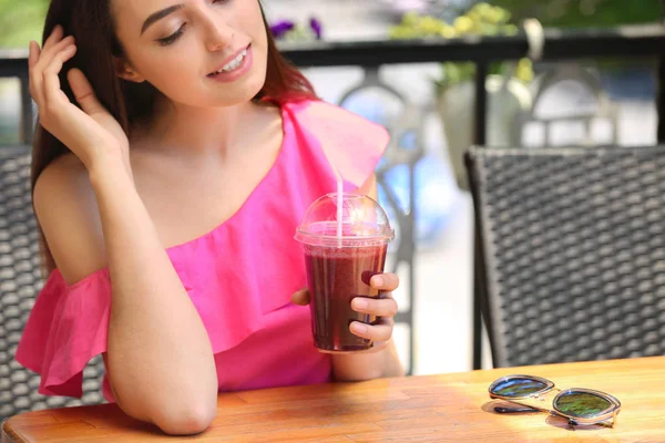 Живая молодая женщина пьет свежий смузи в кафе — стоковое фото