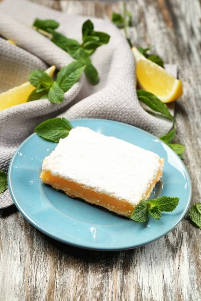 Deliciosa barra de pastel de limón sobre fondo rústico de madera — Foto de Stock