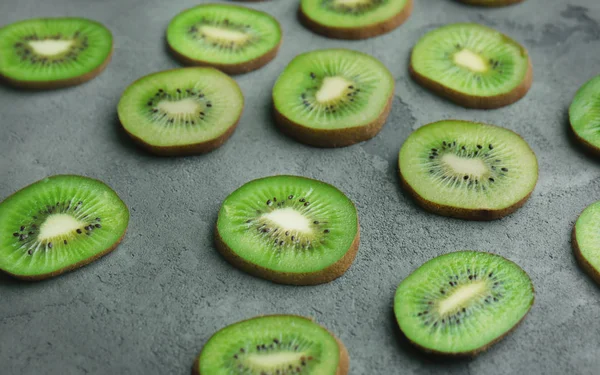 Scheiben grüne reife Kiwi auf grauem Hintergrund — Stockfoto