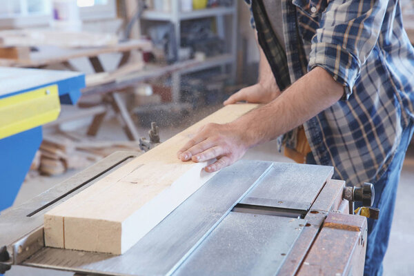 Young carpenter working with circular saw 