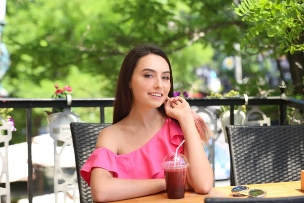 Jovem animada bebendo smoothie fresco no café — Fotografia de Stock