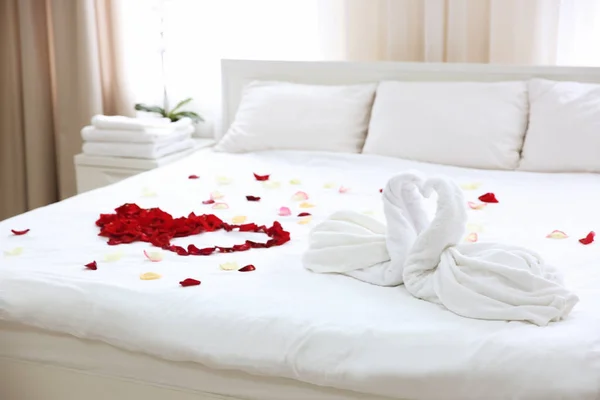 Two towel swans and rose petals — Stock Photo, Image