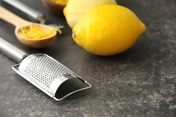 Râpe en métal avec citrons et zeste dans la cuillère sur la table — Photo