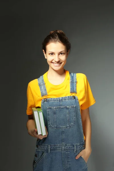 Estudiante femenina con libros sobre fondo gris —  Fotos de Stock