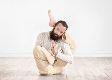 Genç adam pratik Yoga ışık duvar arka plan üzerinde