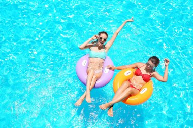 Güzel genç kızlar mavi Yüzme Havuzu içinde şişme yüzük