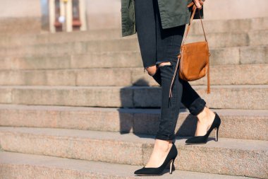 Alt katta açık havada yürüyüş topuklu ince bacaklı genç kadın