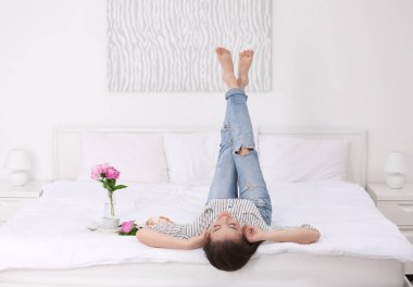 Güzel genç kadın otel odasında yatak yatan