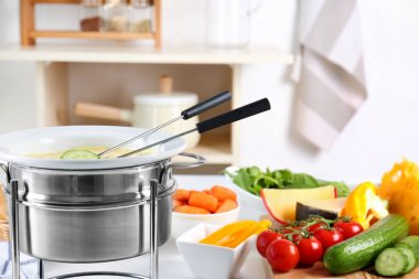 Mutfak masasında tencerede peynir fondü