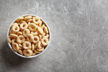 Gri arka plan üzerinde sağlıklı Mısır halkalar ile kase