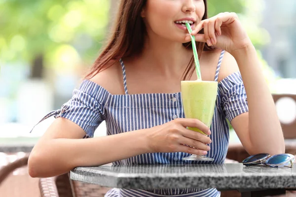 かなり若い女性のカフェで飲むスムージー — ストック写真