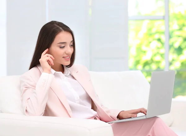 Beautiful young business lady using laptop in hotel room — Stock Photo, Image