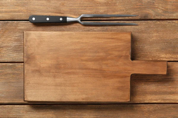 Forquilha de carne e placa no fundo de madeira — Fotografia de Stock