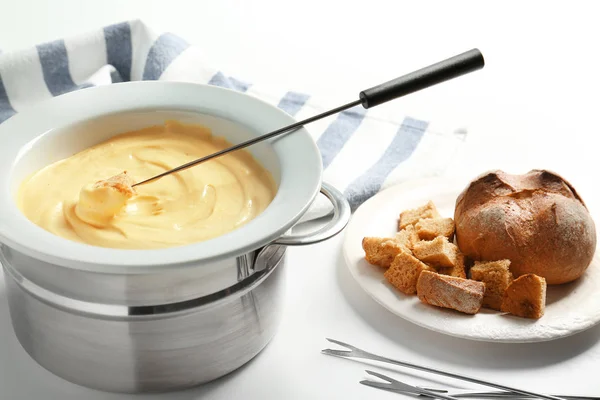 Palillo con trozo de pan en fondue de queso en la mesa — Foto de Stock