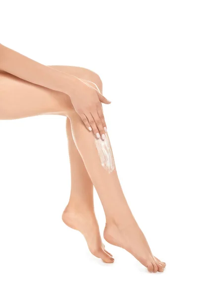 Жінка наносить крем на ногу — стокове фото