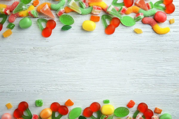 Different candies on wooden background — Stock Photo, Image