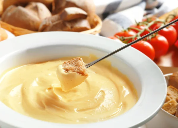 Sumergiendo palo con trozo de pan en fondue de queso, primer plano — Foto de Stock