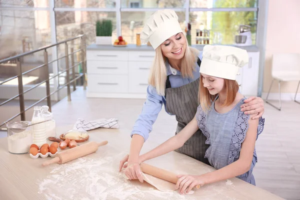 Mãe e filha rolando massa na cozinha leve — Fotografia de Stock