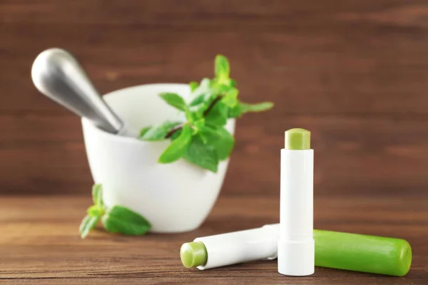 Lápices labiales higiénicos con bálsamo de limón sobre mesa de madera — Foto de Stock