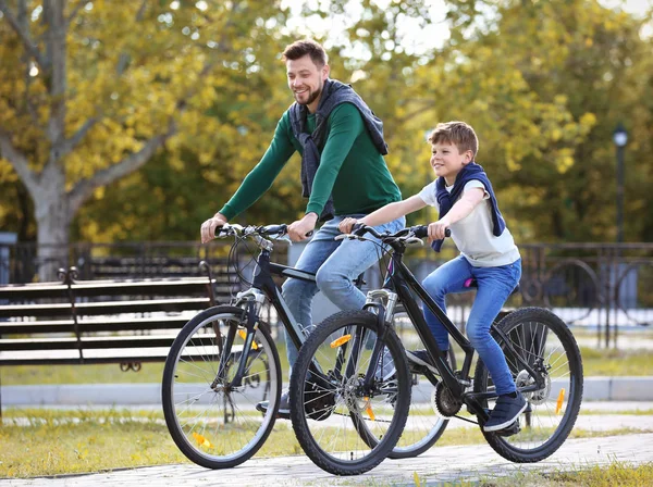 Dad and son riding bicycles outdoors — Stock Photo, Image