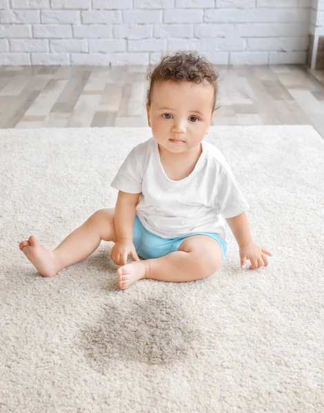 Niña adorable sentada en una alfombra cerca de un lugar húmedo — Foto de Stock