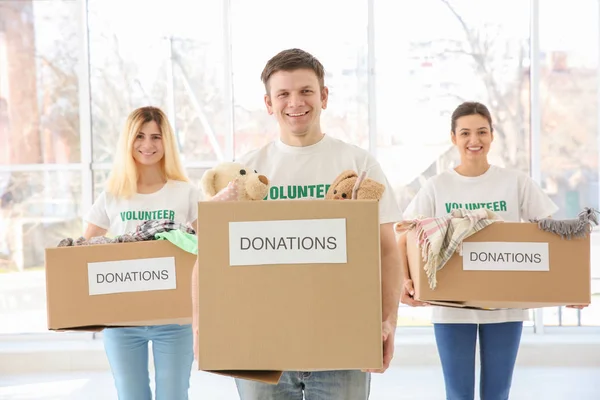 Voluntarios con cajas dentro. Concepto de pobreza — Foto de Stock