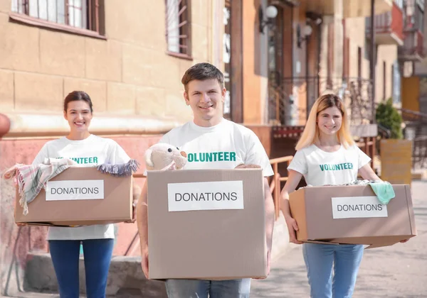 Voluntarios con cajas al aire libre. Concepto de pobreza — Foto de Stock