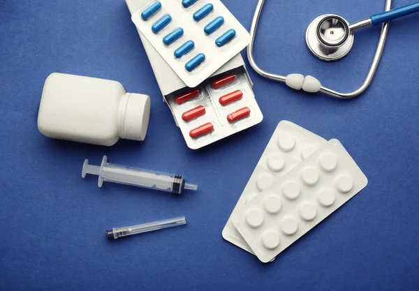 Concepto de salud. Composición con pastillas y material médico sobre fondo azul — Foto de Stock