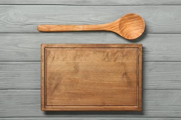 Tablero y cuchara sobre fondo de madera — Foto de Stock