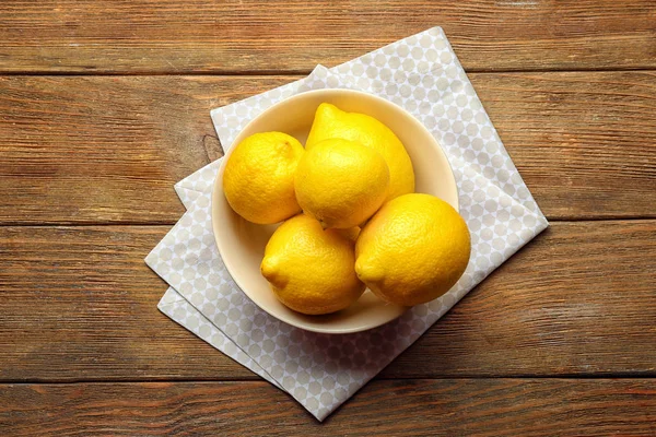 Bol avec de délicieux citrons sur une table en bois — Photo