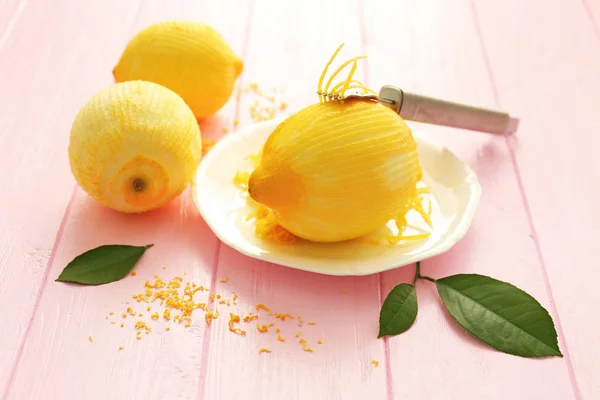 Limoni pelati freschi e scorza sul tavolo di legno — Foto Stock