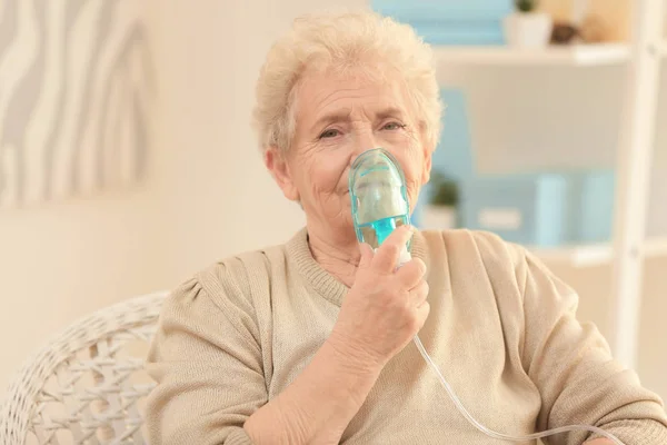 Mujer anciana que usa la máquina del asma en casa — Foto de Stock