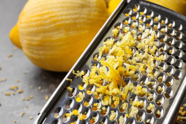 Grater with lemon zest on table, closeup — Stock Photo, Image