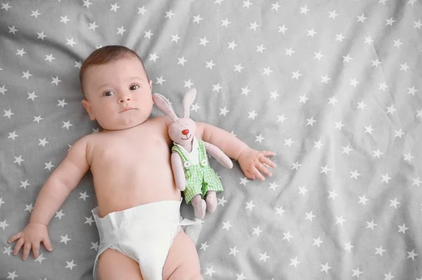 Lindo bebé con juguete acostado en la cama en casa — Foto de Stock