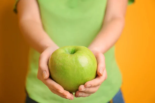 Yeşil elma renk arka plan, closeup üzerinde elinde tutan genç kadın — Stok fotoğraf