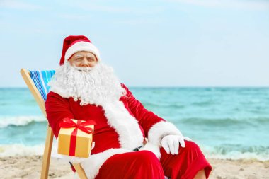 Otantik Noel Baba hediye kutusunda plajda şezlong ile