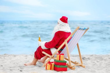 İçki rahatlatıcı plajda şezlong içinde şişe ile otantik Noel Baba