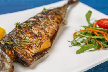 Izgara balık sebze ile beyaz plaka üzerinde