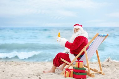 İçki rahatlatıcı plajda şezlong içinde şişe ile otantik Noel Baba
