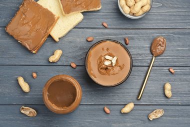 Kase ve kavanoz lezzetli fıstık ezmesi ve ahşap masa üzerinde tost ile