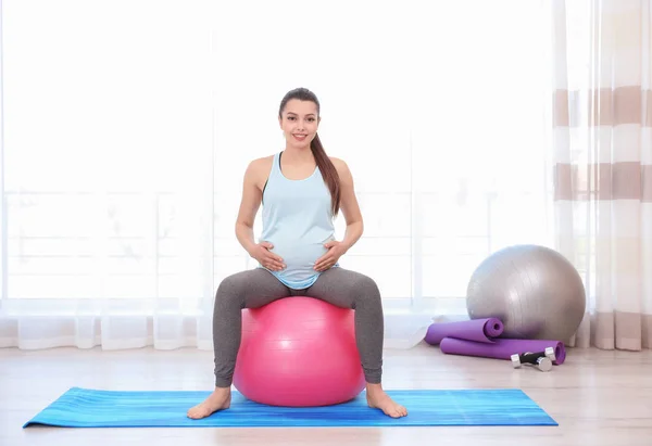 Mujer embarazada joven entrenando en el gimnasio. Concepto de salud —  Fotos de Stock