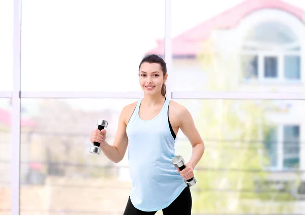 Mujer embarazada joven entrenando en el gimnasio. Concepto de salud — Foto de Stock