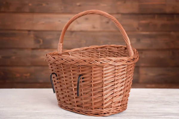 Cesta de vime de bicicleta na mesa de madeira — Fotografia de Stock