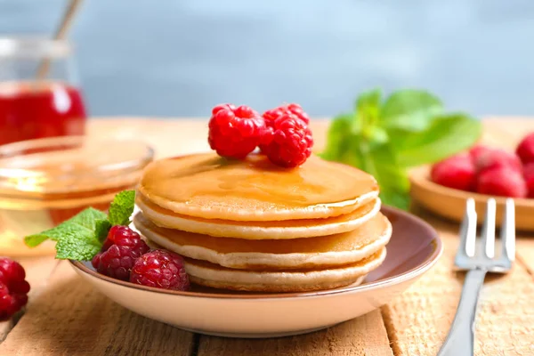 Teller mit leckeren Pfannkuchen auf dem Tisch — Stockfoto