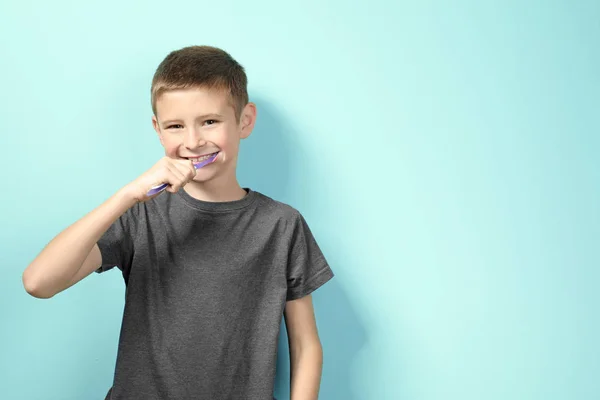 컬러 배경에 치아를 청소 하는 귀여운 어린 소년 — 스톡 사진