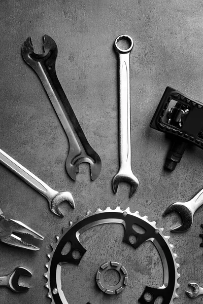 Fahrradteile und Reparaturwerkzeuge auf grauem Hintergrund — Stockfoto
