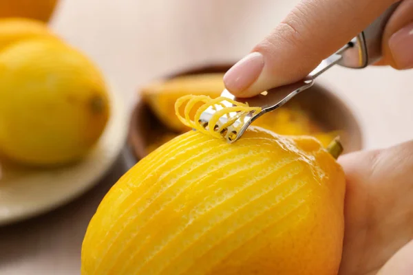 Mulher tirando casca de limão com zester, close-up — Fotografia de Stock